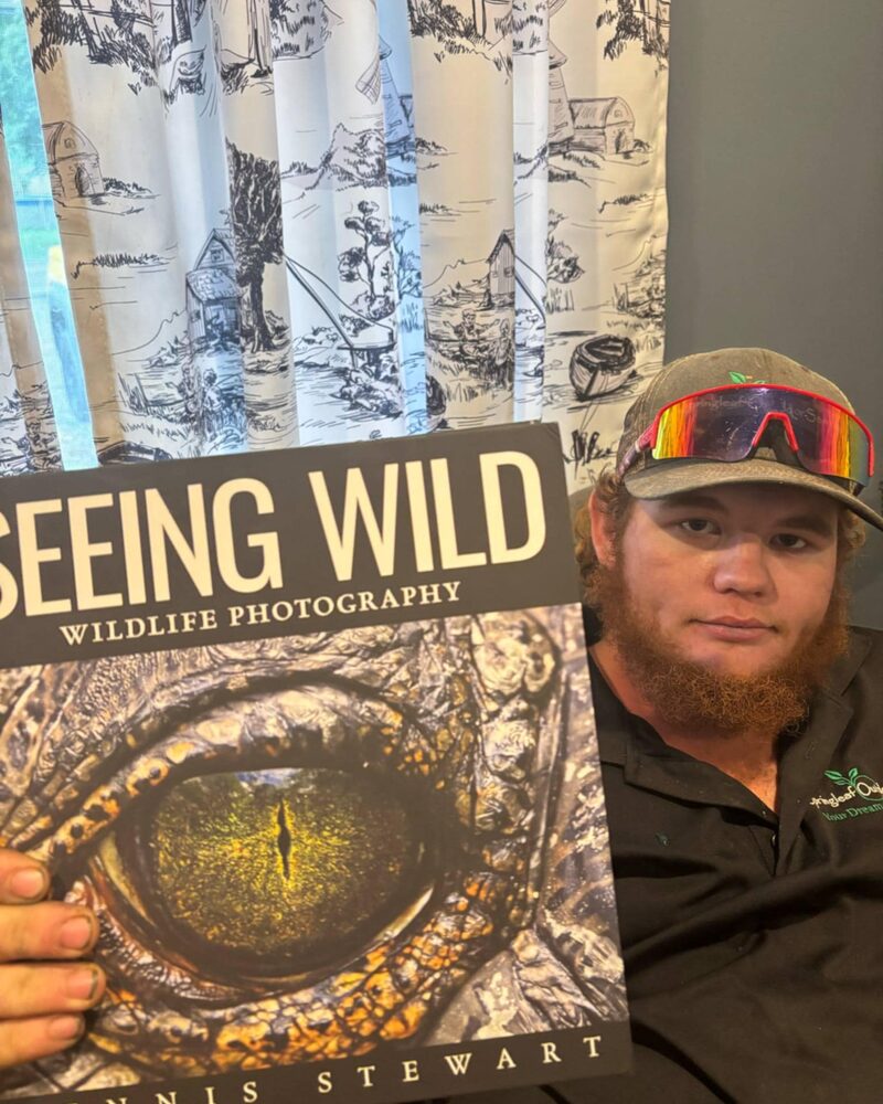 Reader in a colorful cap holding Seeing Wild