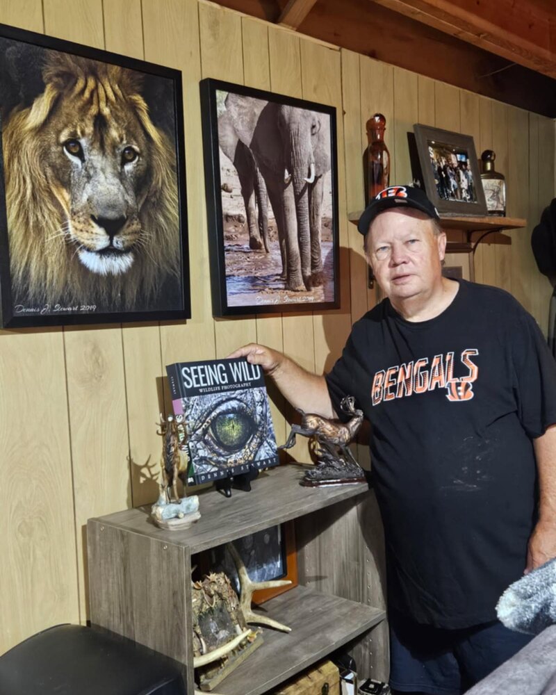 Reader holding Seeing Wild beside wildlife artwork