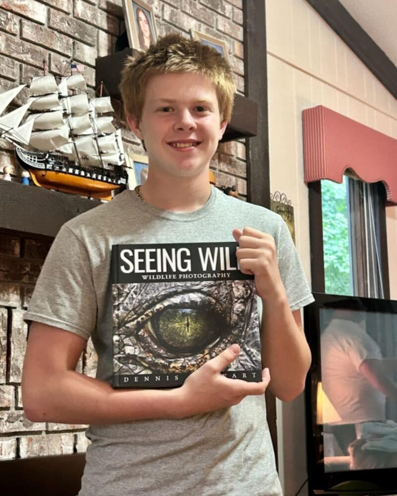 Young reader holding a copy of Seeing Wild
